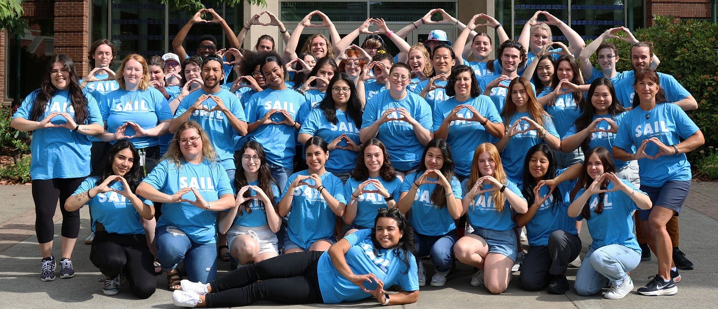 Group of SAIL participants pose while making "O" with hands