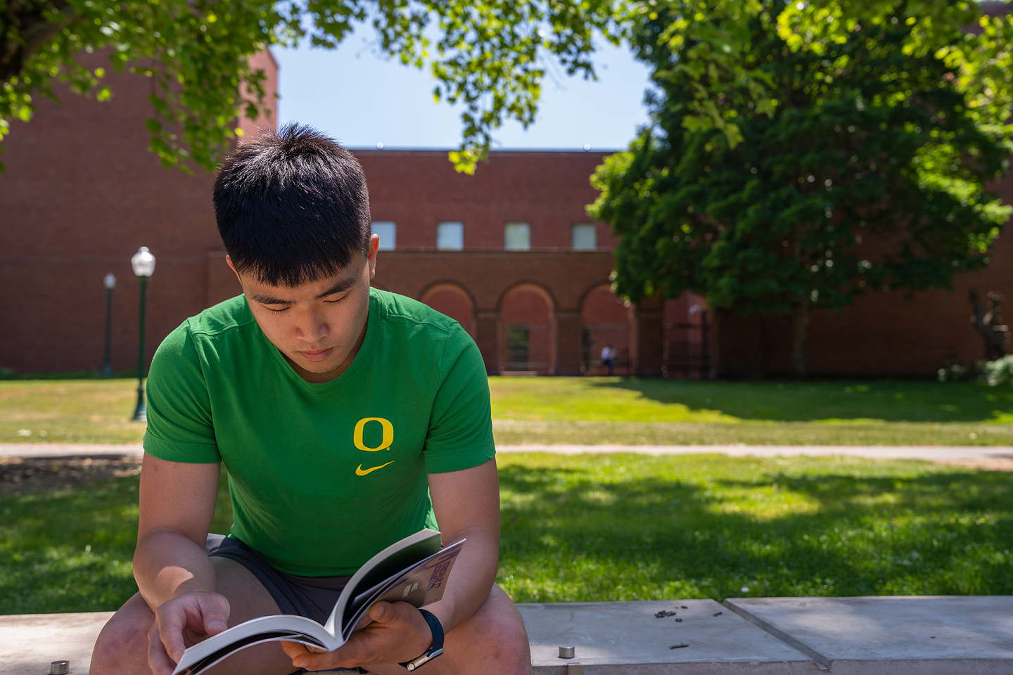 a student sitting and reading outside
