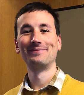 Man in yellow shirt and smiling