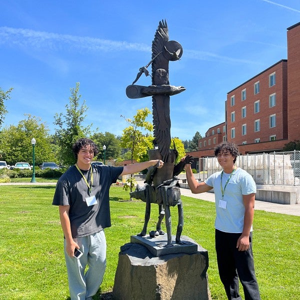 SAIL students stand next to totem pole