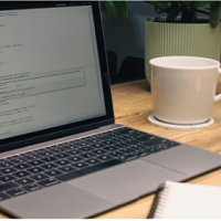 Desk with open computer and cup of coffee